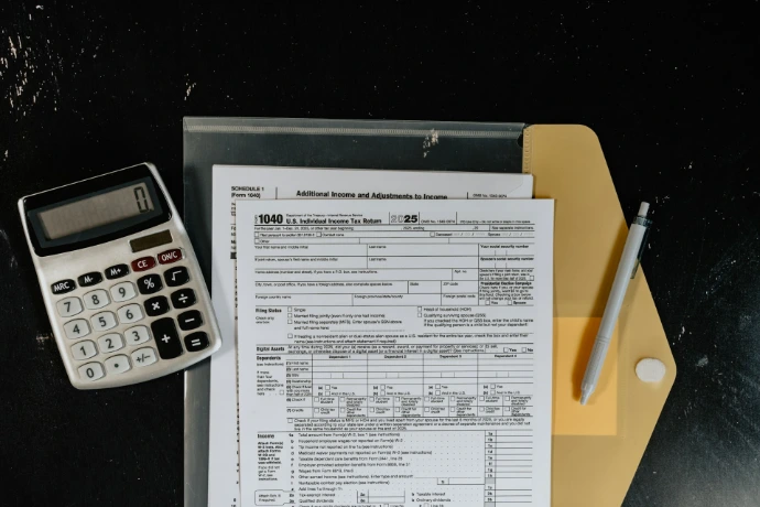 Calculator and tax forms on a dark surface